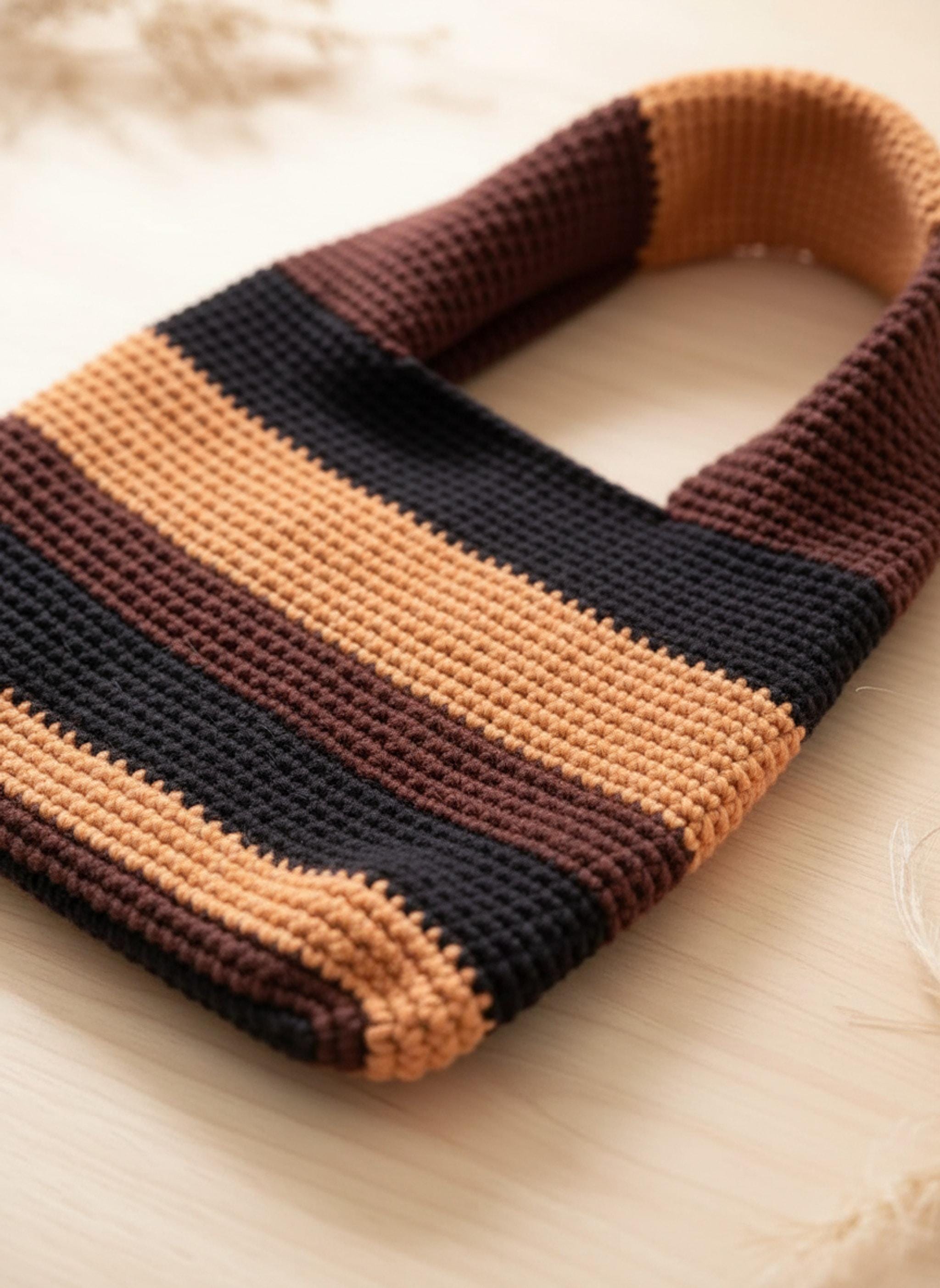 Close-up of the brown and orange striped crochet tote bag, showing the detailed stitch work and the texture of the yarn.