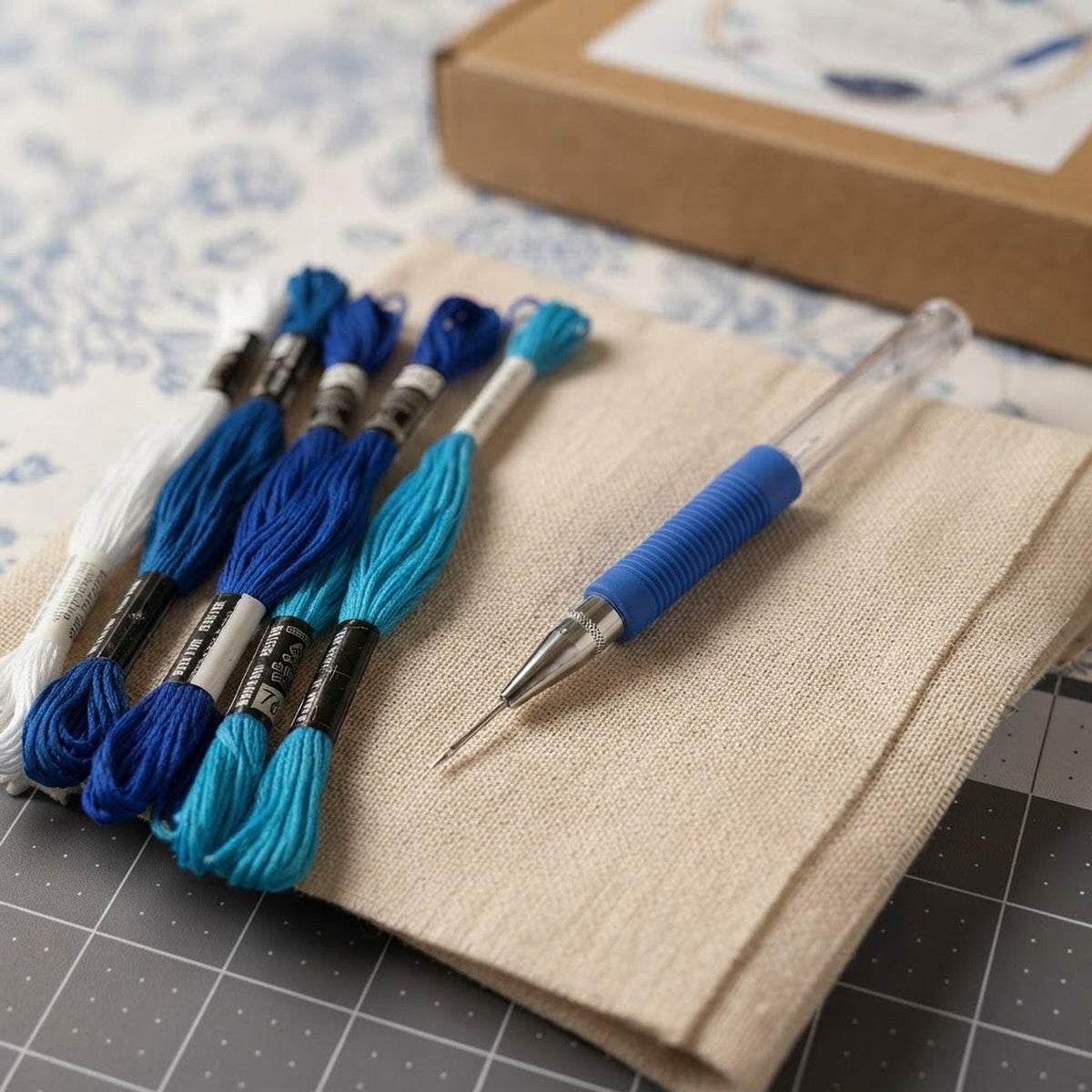 Close up view of embroidery floss, punch needle tool, and fabric texture