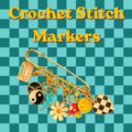 A large gold safety pin holds seven enamel charms including a cassette tape, yin-yang, lightning bolt, daisy, mushroom, smiley face, and checkered heart against a teal checkered background with yellow text reading Crochet Stitch Markers.